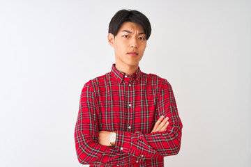 Young chinese man wearing casual red shirt standing over isolated white background skeptic and...