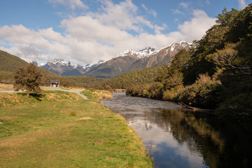 Naklejka na ściany i meble Beautiful calm river winding its way through the Southern Alps in Fiordland New Zealand