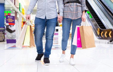 Couple with colourful shopping bags walking in mall