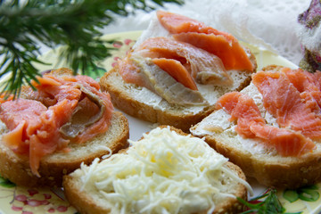 three sandwiches with red fish, one with cheese. snack