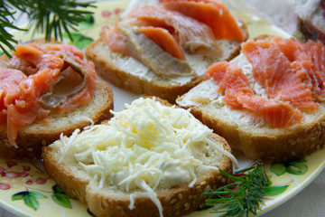 three sandwiches with red fish, one with cheese. snack