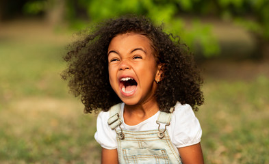 Little girl screaming over natural summer background