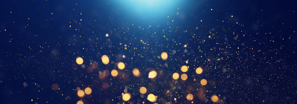 background of abstract glitter lights. blue, gold and black. de focused. banner