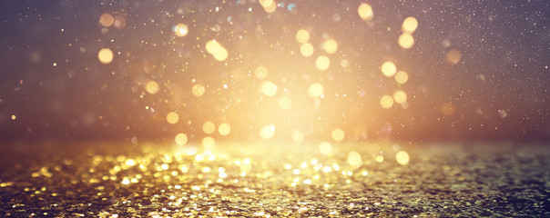 background of abstract glitter lights. gold and black. de focused. banner
