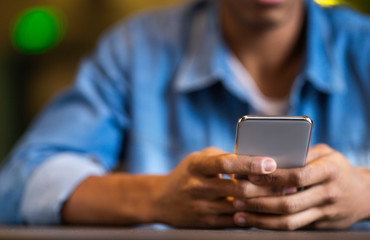 Young black guy in causal clothes using cellphone