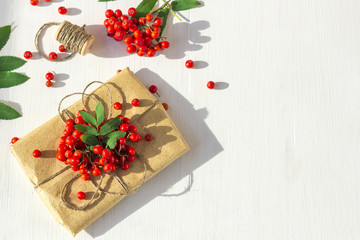 Autumn floral composition. Bunch of mountain ash (rowan) on a white wooden rustic background.