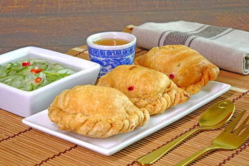 Curry puff. Chicken curry puff (or Karipap) is a snack of Southeast Asian origin. It is a small pie consisting of curry with chicken and potatoes in a deep-fried or baked.