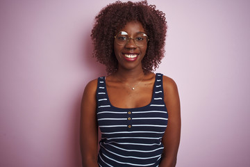 Young african afro woman wearing striped t-shirt glasses over isolated pink background with a happy and cool smile on face. Lucky person.