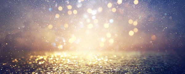 background of abstract glitter lights. blue, gold and black. de focused. banner