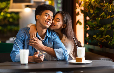 Teen couple in love cuddling at cafe during date