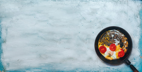 Fried egg pan. Breakfast with fried eggs and vegetables
