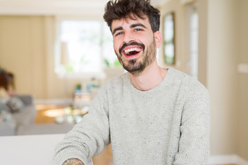 Handsome young man smiling cheerful at the camera with a big smile on face showing teeth