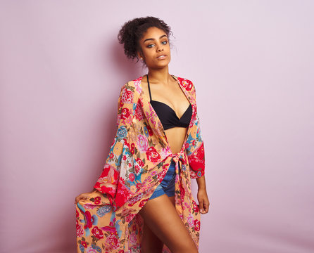 Young beautiful african american woman on vacation standing wearing bikini and colorful caftan