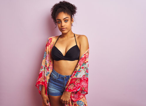 Young beautiful african american woman on vacation standing wearing bikini and colorful caftan
