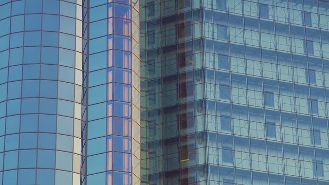 Glass Elevator Going Down the Glazed Facade of Skyscraper. Glass Curtain Facade Wall Background.