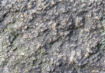 Macro close-up of a rough rock surface with fine grains of sand. High resolution full frame textured background.