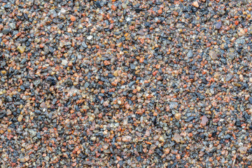 Macro close-up of wet sand, viewed from above. High resolution full frame textured background.