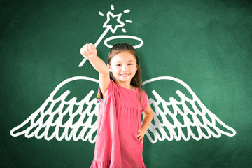 little girl standing against chalkboard and magic   concept