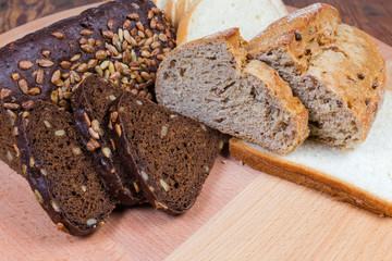 Partly sliced various bread on the wooden surface close-up