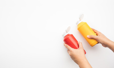 Youngwoman squeezing bottles sauce ( mustard,ketchup) for dipping on white background