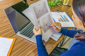 Female accountant reading and analyzing financial reports in the office