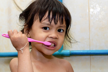 Little asian cute girl brush teeth in bathroom.