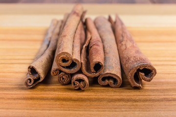 Dried cinnamon sticks on the wooden surface close-up