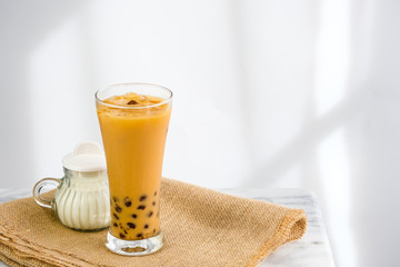 Bubble milk tea with milk  and bubble topping for tea or other beverage on the wood table with copy-space for text.
