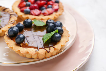 Sweet tartlet with berries on plate, closeup