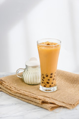Bubble milk tea with milk  and bubble topping for tea or other beverage on the wood table with copy-space for text.
