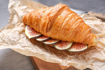 Sweet croissant and fig fruit slices on table, closeup