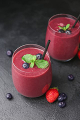 Glasses of acai smoothie on dark background