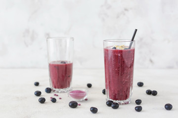 Glass of acai smoothie on light background