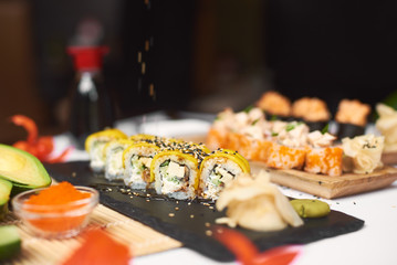 Oriental meal made from rice and seafood. Delicious lunch from three courses in luxury Japanese restaurant. Gourmet set from sushi rolls served with soy sauce, wasabi, marinated ginger.