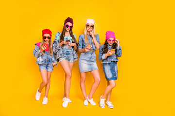 Fototapeta premium Full size body photo of interested luxurious denim little ladies and pretty charming nice glad positive millennial teenagers using digital gadget devices isolated bright background