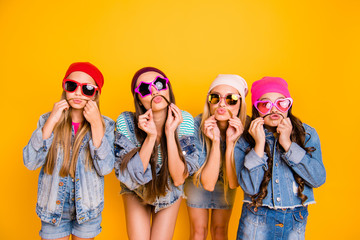 Close up photo of group of four fashionable fancy trendy comic laughing carefree careless teenagers having fun and good mood isolated vibrant yellow background