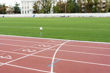 Obraz premium Running track with grass field on sunny day
