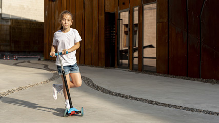 Front view of girl with blue scooter