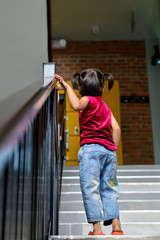 Children girl are climbing up the stairs alone.