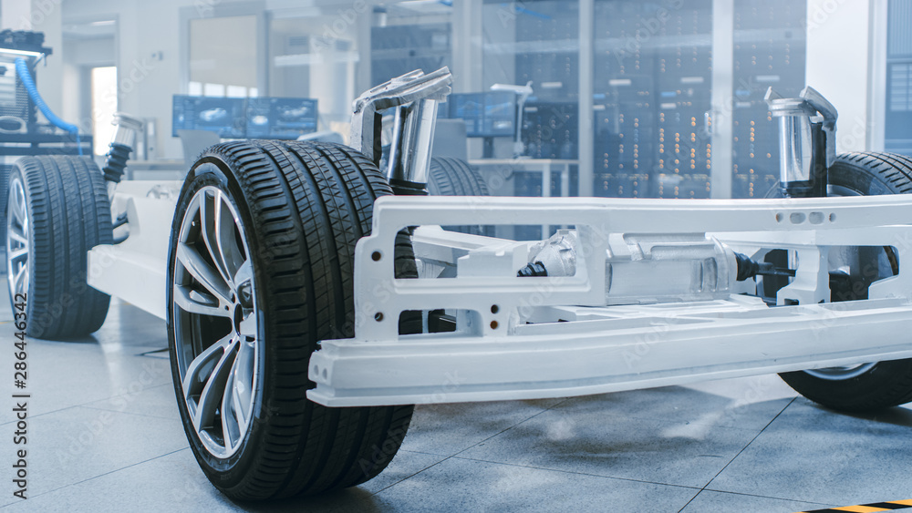 Poster concept of authentic electric car platform chassis prototype standing in high tech industrial machin