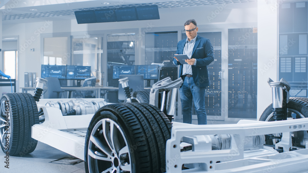 Aufkleber automotive design engineer looking at technical drawing of an electric car chassis prototype on a ta