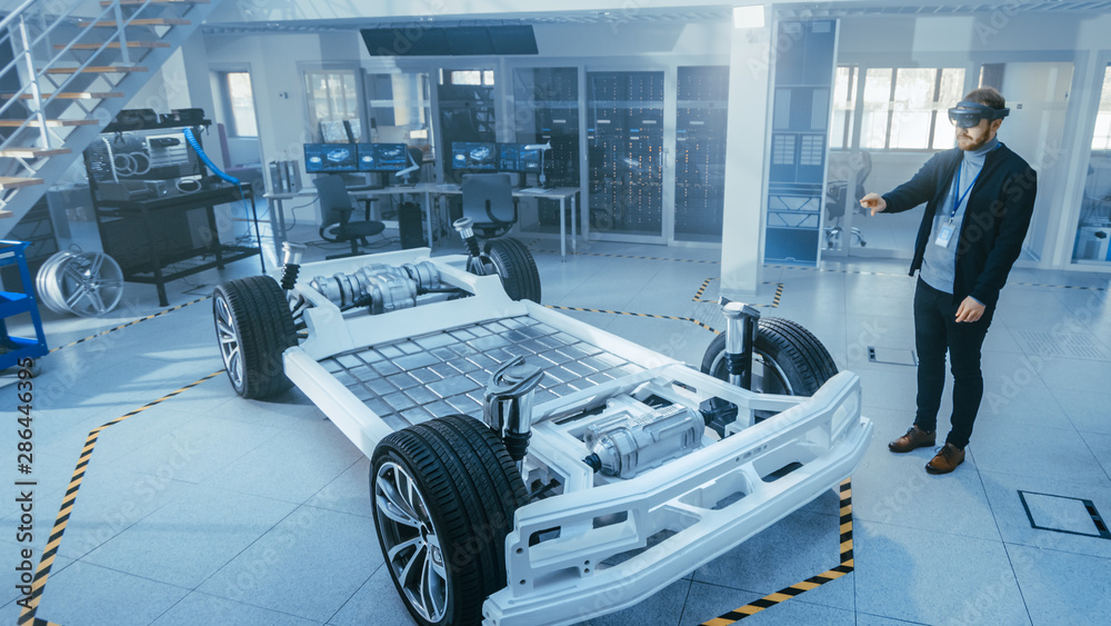 Poster automotive engineer working on electric car chassis platform, using augmented reality headset. in in