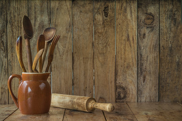 Vintage wooden utensils in the jug and rolling pin on the rustic wooden background with copy space - Powered by Adobe