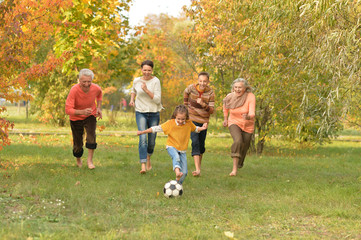 Portrait of big happy family playing football in park