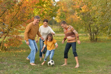 Naklejka na ściany i meble Portrait of big happy family playing football in park