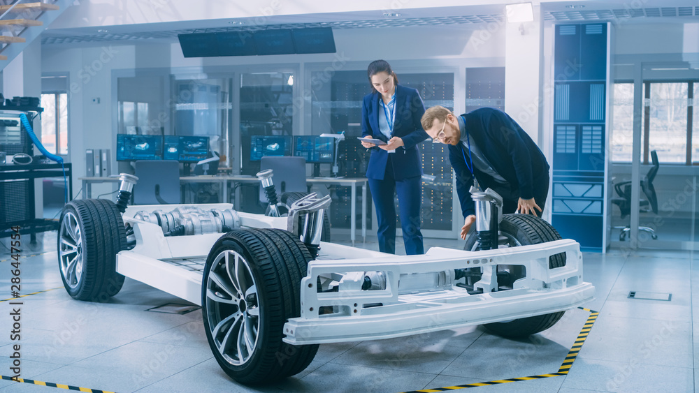 Poster automotive design engineers working on electric car chassis prototype. in innovation laboratory faci