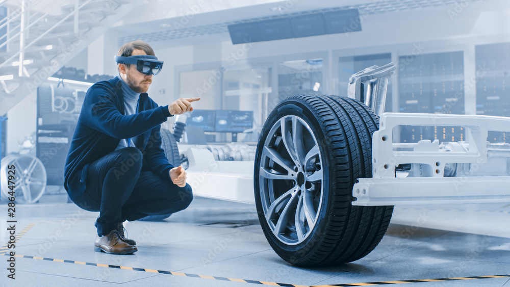 Poster automotive engineer working on electric car chassis platform, using augmented reality headset. in in