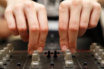 Close up wide angle shot of female dj hands adjusting frequency knobs on sound mixer...