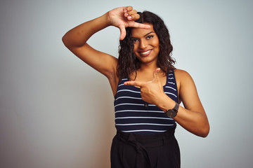 Transsexual transgender woman wearing striped t-shirt over isolated white background smiling making frame with hands and fingers with happy face. Creativity and photography concept.