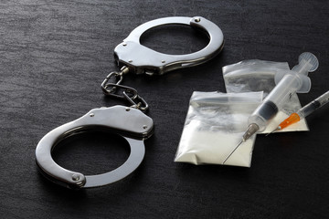 Police handcuffs and syringe with drug